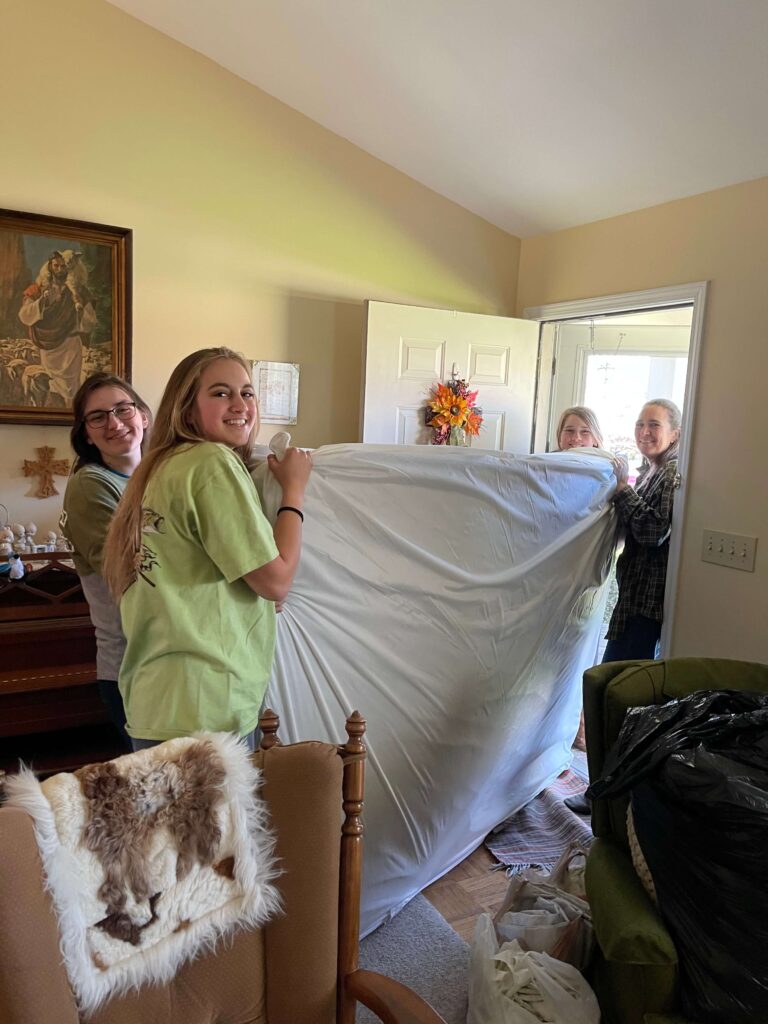 Volunteers moving a mattress